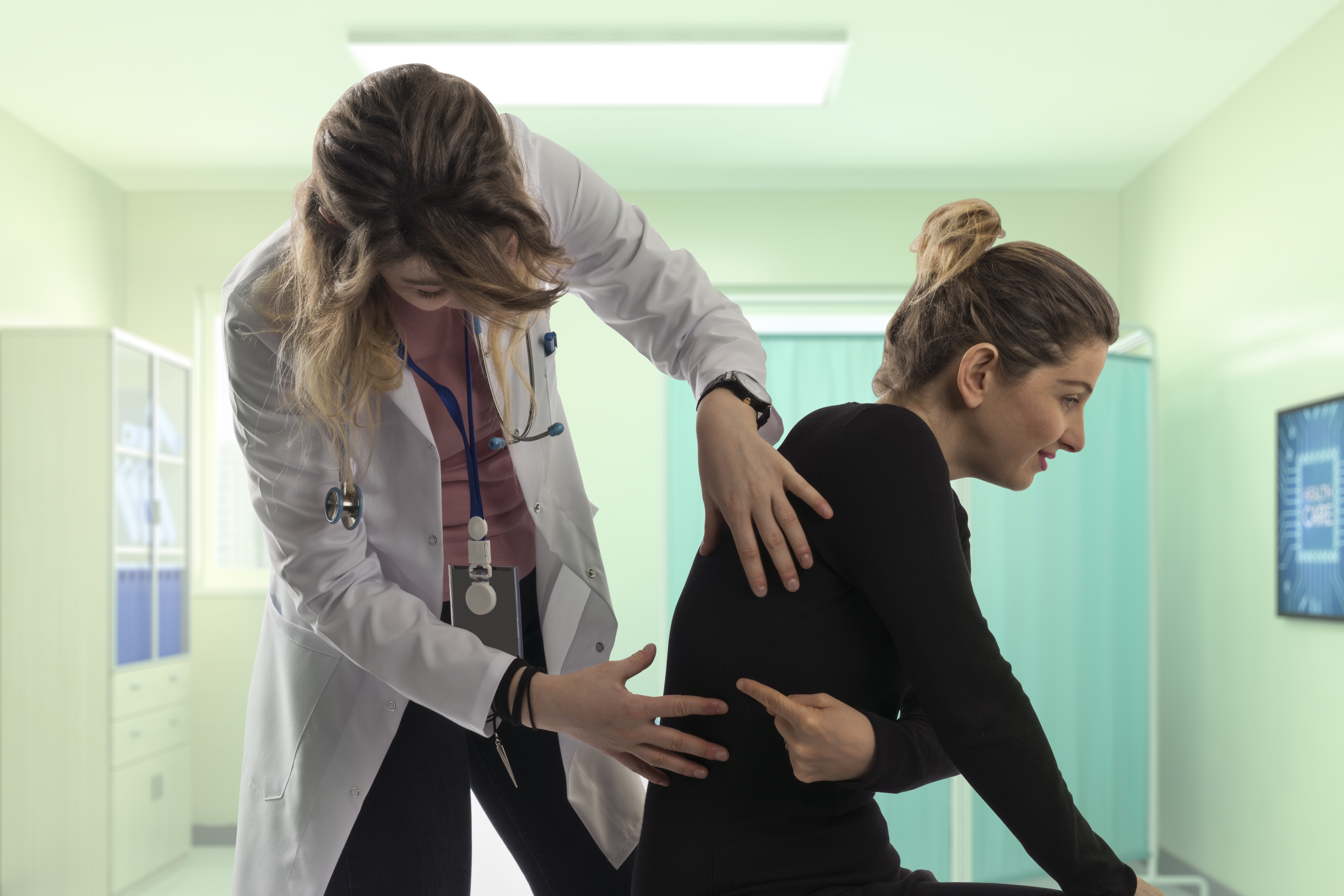 Woman showing chiropractor where her back pain is